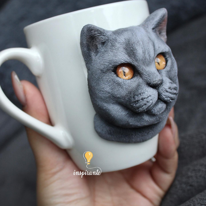 Polymer clay cat mug with lifelike features, German Spitz style in background