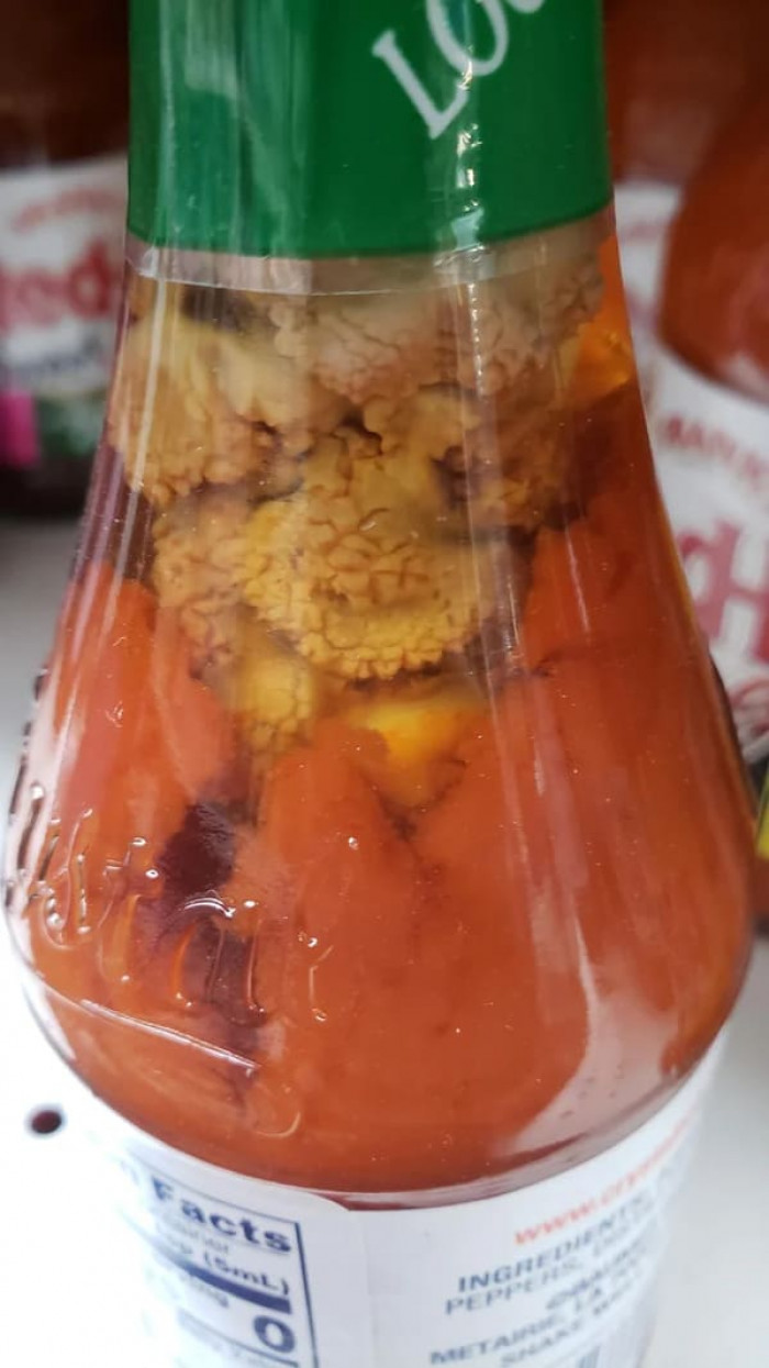 12. “Found this nightmare growing in a bottle of Crystal hot sauce. The bottle was sealed on the shelf with an 03/03/2024 expiration. Can anyone explain what’s happening here?”