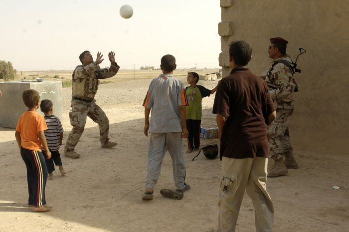4. Iraqi soldiers play football (soccer) with children after a shift in Iraq in 2014.
