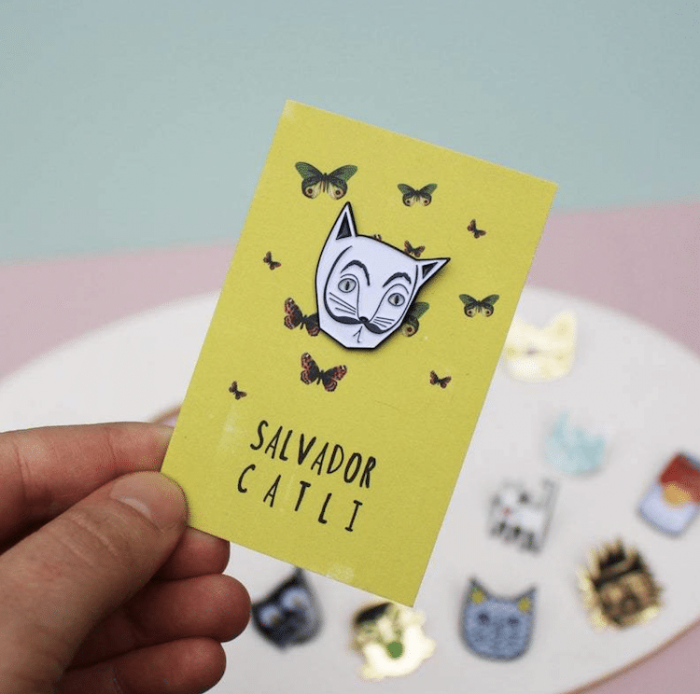 Salvador Dali as Catli, mustache and whiskers cat-themed enamel pin design.