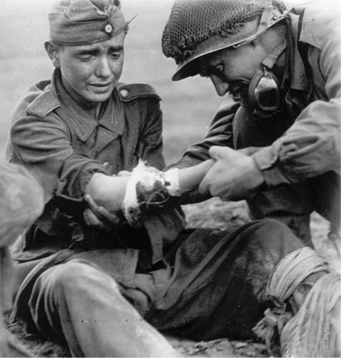 1. An American medic helps a young wounded German solider during WWII in 1944.