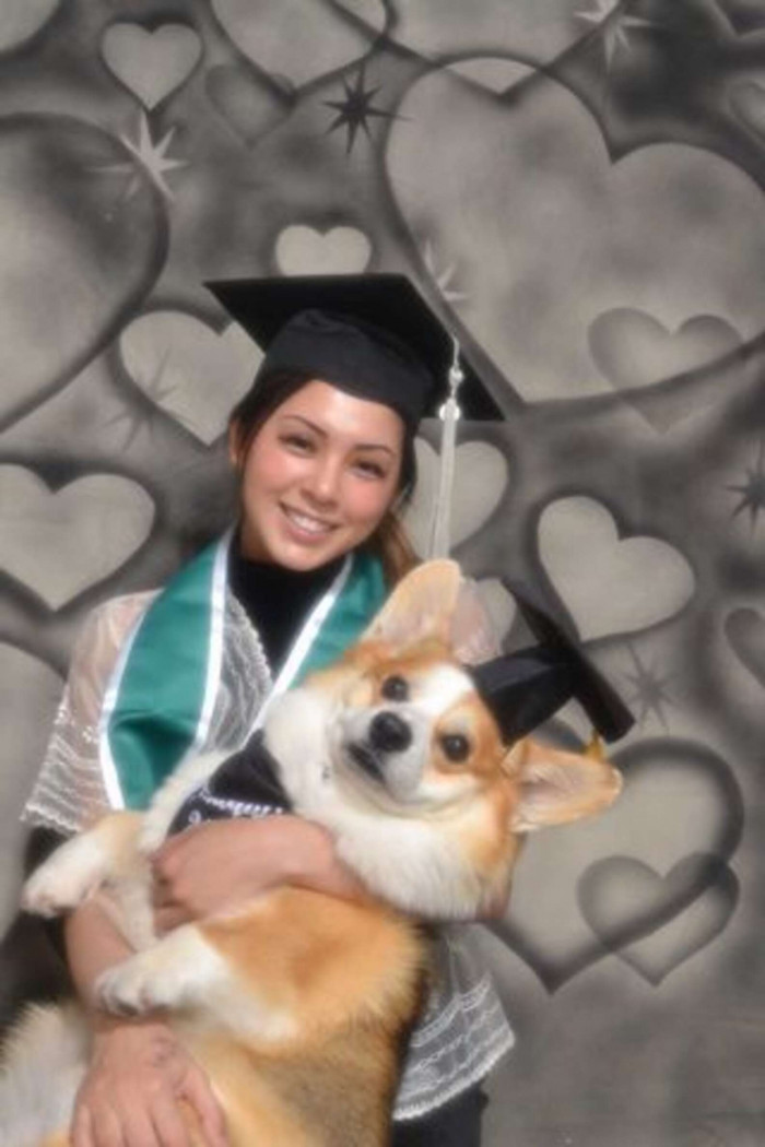 College graduate poses with her dog during a graduation photo shoot