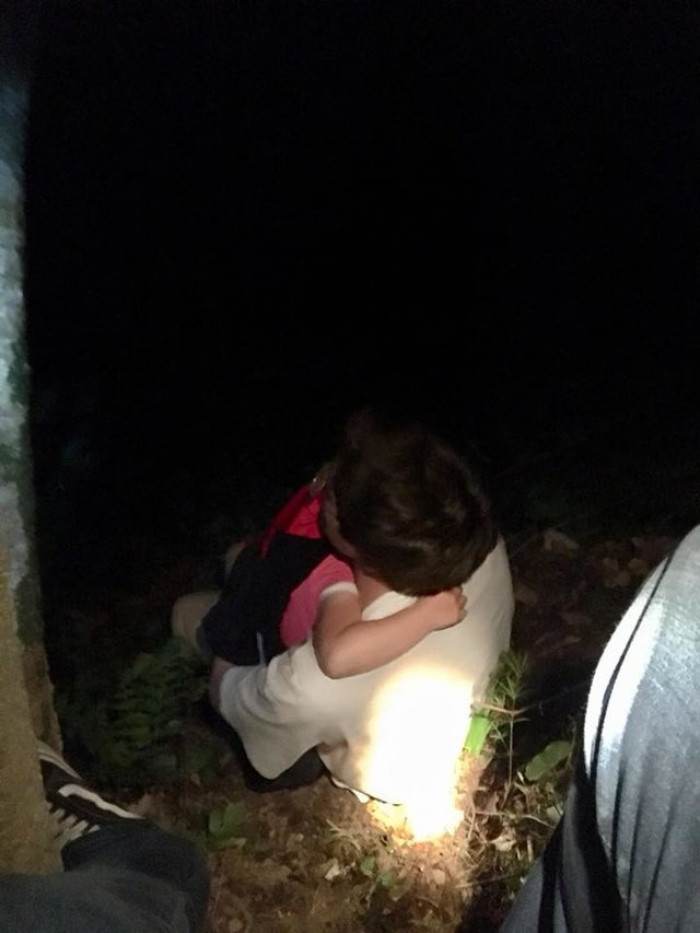 Rescue team members comforting the twins and checking their safety