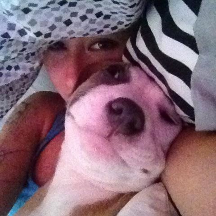 Dog’s head visible from backpack, woman grips handlebars while evacuating