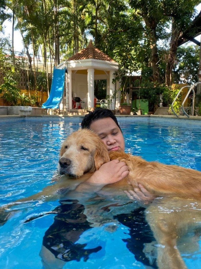 5. “My senior(ish) dog can’t swim by himself anymore, so I carry him while he takes a dip.”