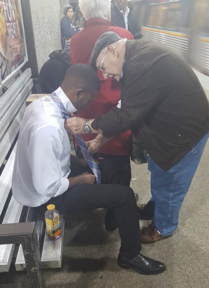 5. This older man helped a young guy tie his tie while they were waiting for the train.