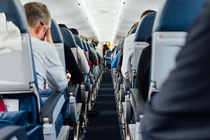 Husband has upgraded his flight ticket to business class and left his wife sitting separately from him in the economy.