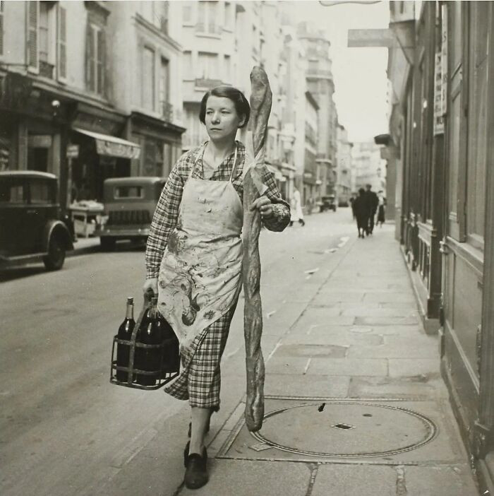 47. A French Woman With A Baguette And Six Bottles Of Wine In Paris, France (1945)