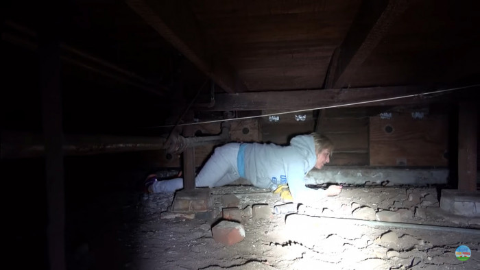 They crawled under the house and tried to corner the dog, but the poor poodle was truly too terrified to come near either of the determined humans.