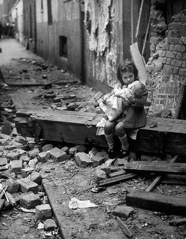 Little girl and her doll amid WWII London rubble during the 1940 bombings