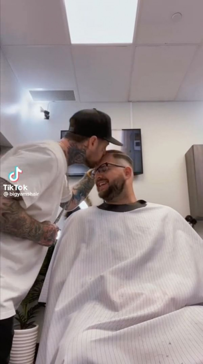 The last thing most customers would anticipate from a face-tatted New Jersey barber is a kiss on the forehead, but it's a hit with his customers