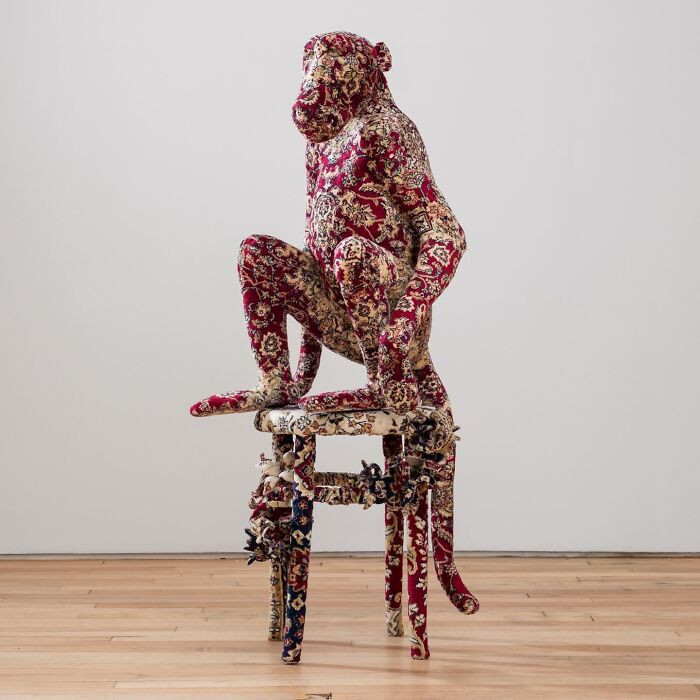 Blue monkey sculpture illusion, wild animal motifs emerging from Persian-style rugs