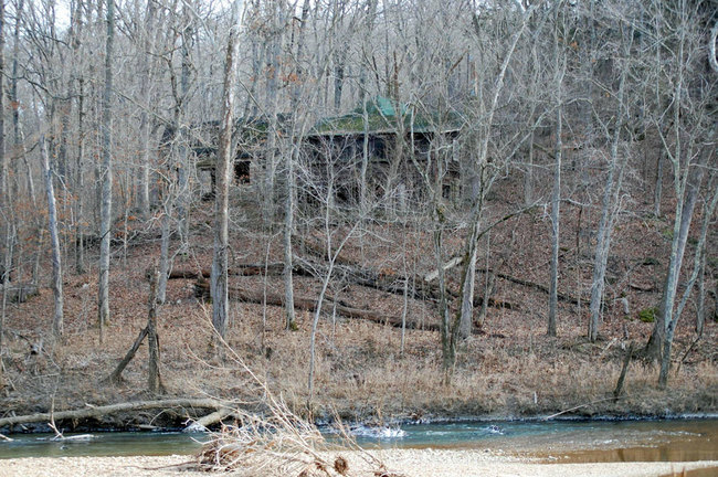 The house happens to be across the river from his property and no one knows who owns it