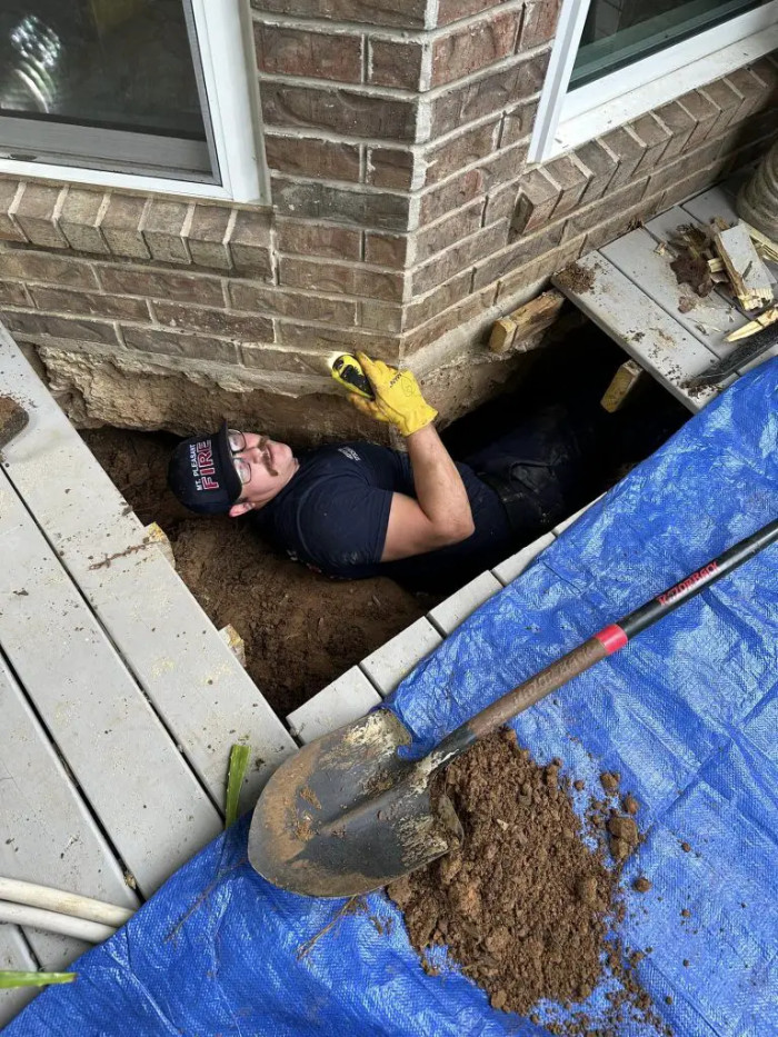 Captured in Photographs, the Dedicated Crew Courageously Ventured into the Depths, Diligently Excavating Beneath the Porch Deck