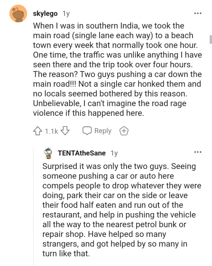 Two guys pushing a car down the main road