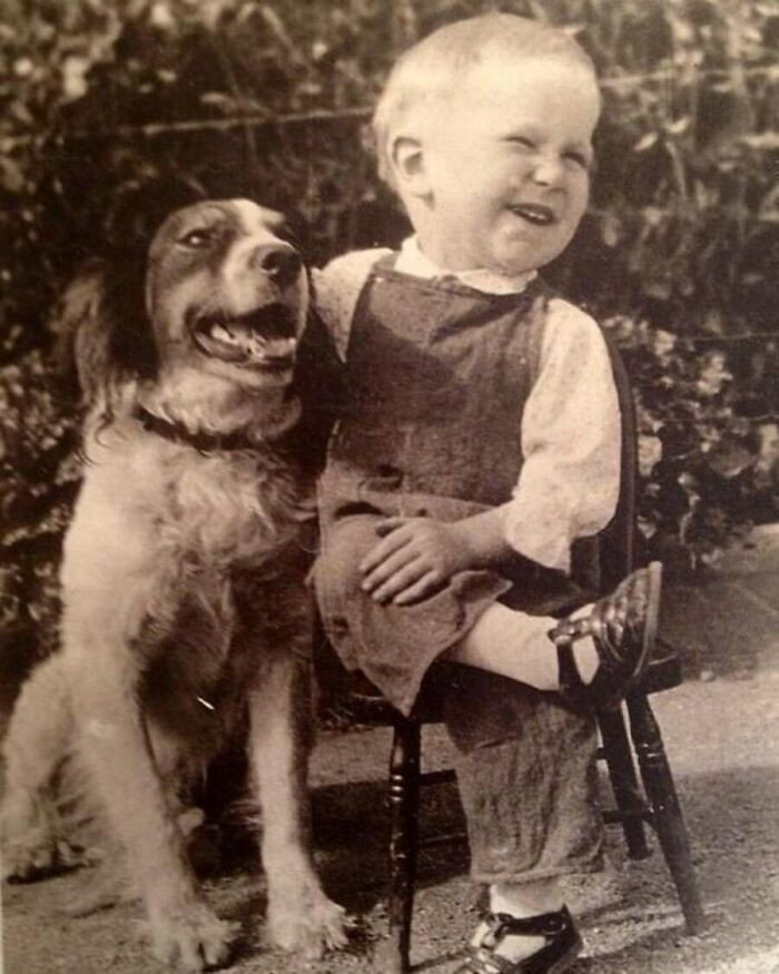 "A boy and his dog share a laugh, 1930s."